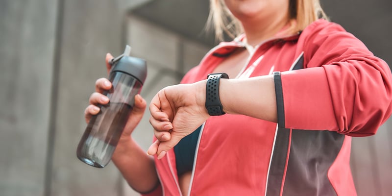 A woman exercising looking at her smart watch