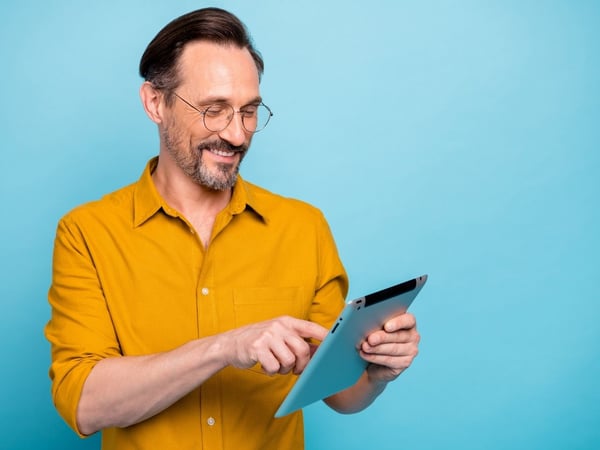 A man standing and reading from the file in his hand