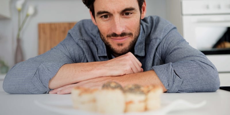 a man sitting on the dining table looking at a plate