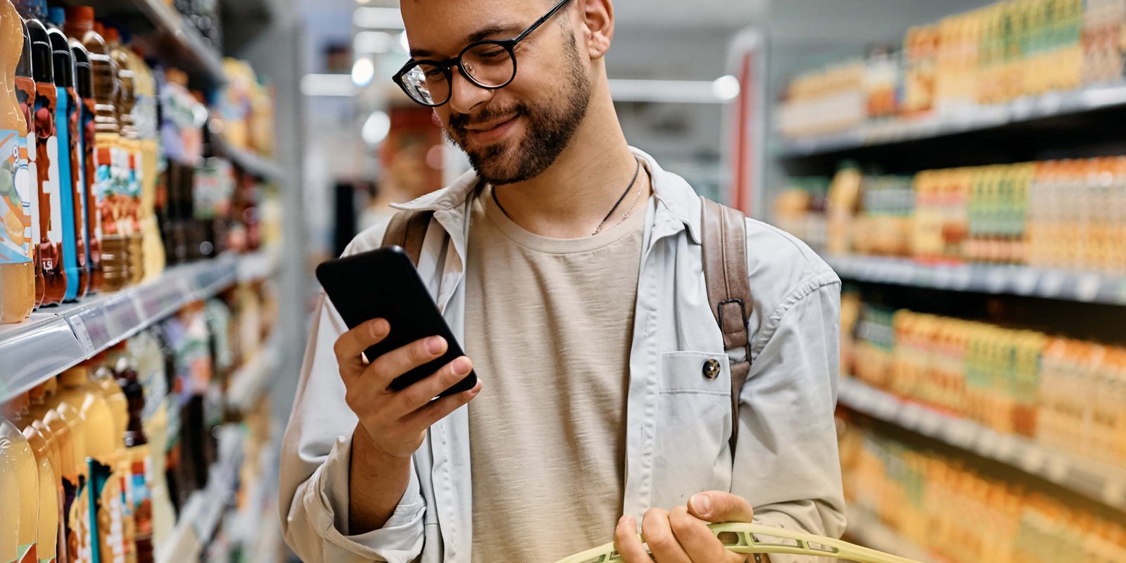 A man in a shop reading about cholesterol on his phone